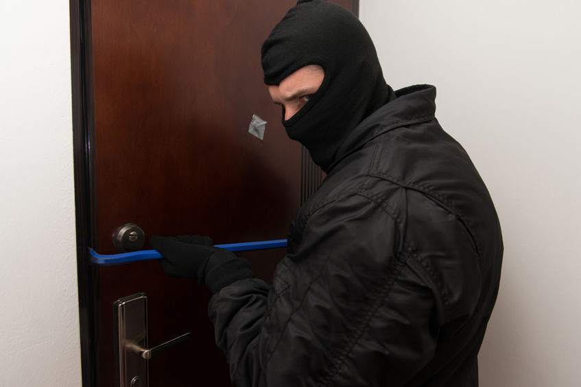 A robber trying to break in to an office